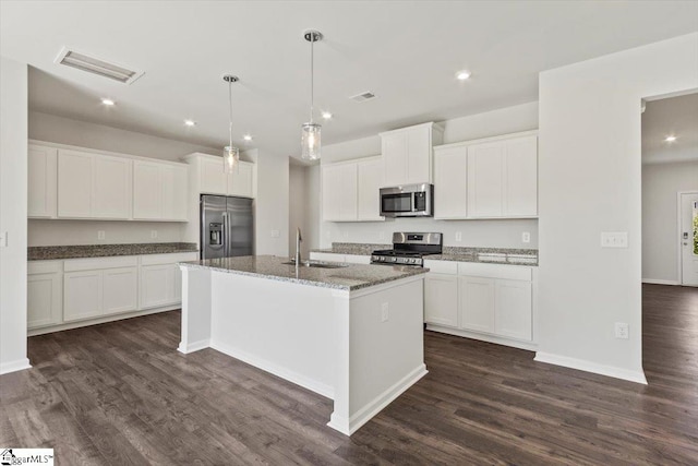 kitchen featuring appliances with stainless steel finishes, dark wood-type flooring, sink, a center island with sink, and white cabinets