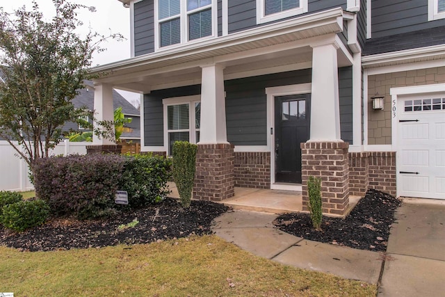 property entrance featuring covered porch and a garage