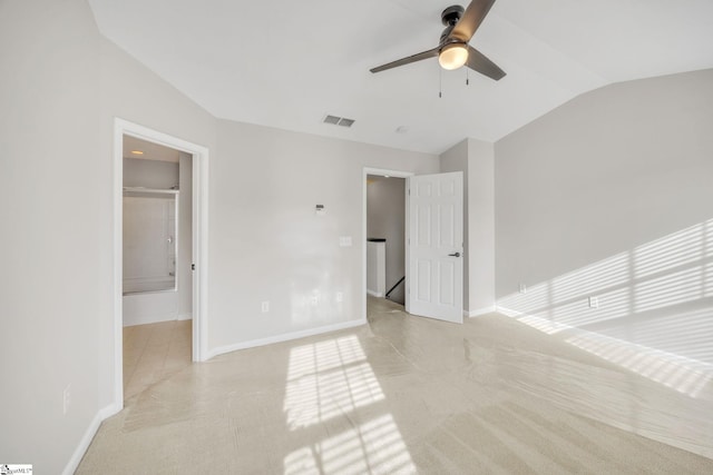 unfurnished bedroom with ceiling fan, lofted ceiling, and ensuite bath