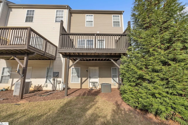 rear view of property featuring a yard, central AC, and a wooden deck