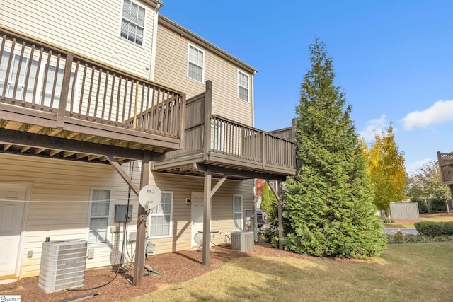 rear view of house featuring a deck, central AC unit, and a lawn