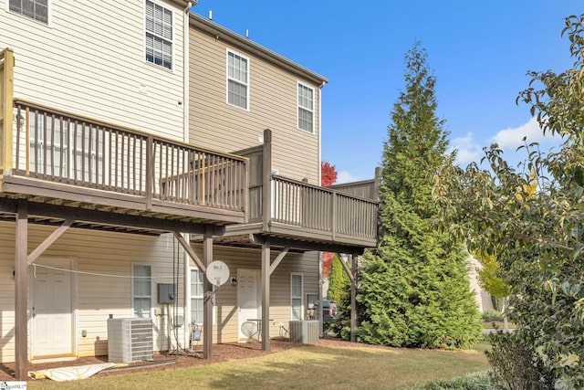 rear view of property featuring a lawn, central AC, and a deck