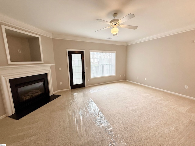 unfurnished living room featuring light colored carpet, ceiling fan, and crown molding