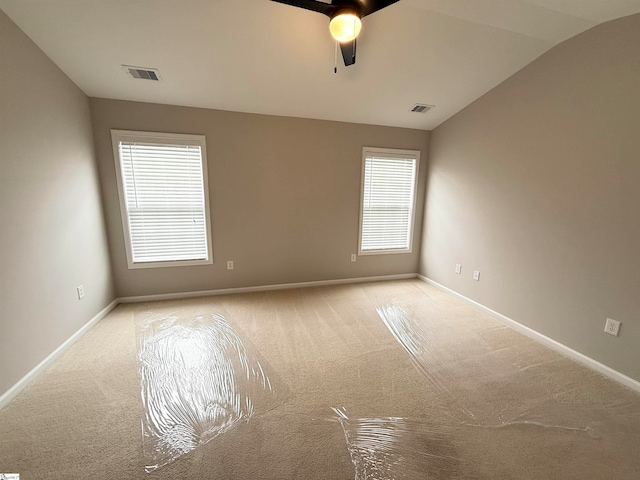 carpeted empty room featuring ceiling fan and lofted ceiling