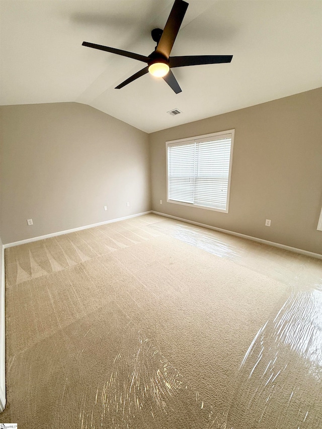 carpeted spare room with vaulted ceiling and ceiling fan