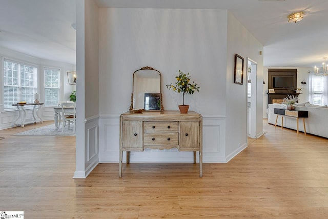 hallway featuring a notable chandelier and light hardwood / wood-style flooring