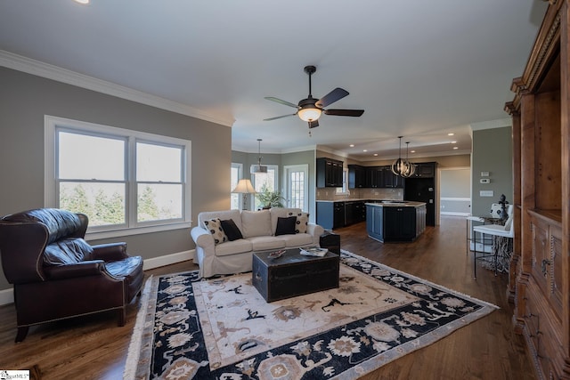 living room with crown molding, ceiling fan, and dark wood-type flooring