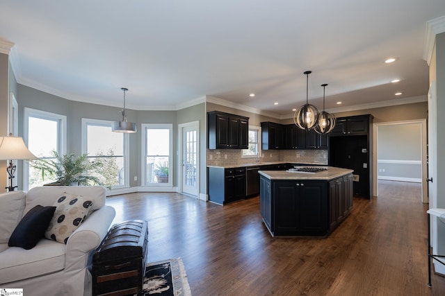 kitchen with dark hardwood / wood-style flooring, ornamental molding, stainless steel appliances, decorative light fixtures, and a center island