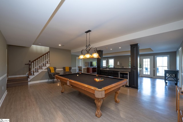 recreation room with a wealth of natural light, billiards, indoor bar, and hardwood / wood-style flooring