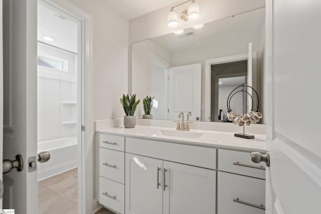 bathroom featuring tile patterned flooring, vanity, and washtub / shower combination