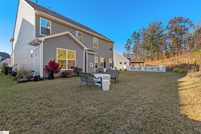 back of house with outdoor lounge area and a yard