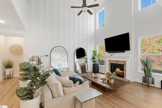 living room with plenty of natural light, a fireplace, and high vaulted ceiling