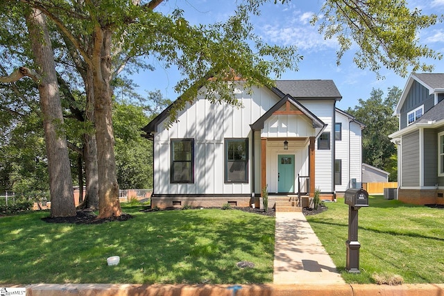 modern farmhouse style home featuring a front lawn and cooling unit