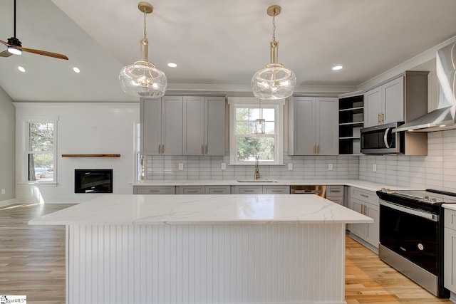 kitchen with a healthy amount of sunlight, a kitchen island, and stainless steel appliances