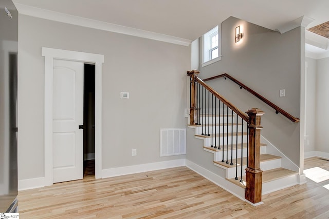 stairs featuring wood-type flooring and ornamental molding