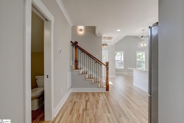 hallway featuring a notable chandelier, light hardwood / wood-style floors, and crown molding