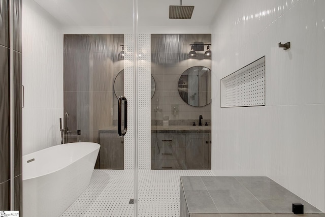 bathroom with vanity, separate shower and tub, and tile walls