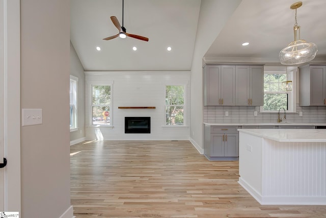 kitchen with gray cabinets, ceiling fan, a healthy amount of sunlight, and light hardwood / wood-style floors