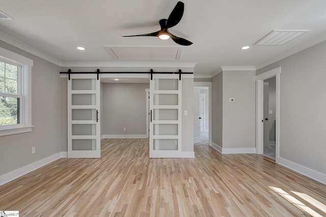 unfurnished bedroom with ceiling fan, a barn door, ornamental molding, and light hardwood / wood-style flooring