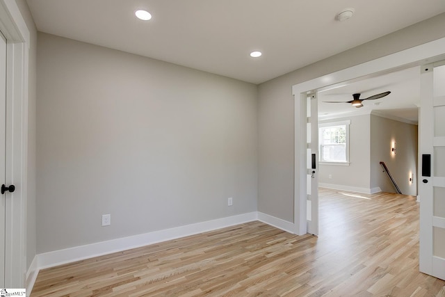 empty room with light wood-type flooring, ceiling fan, and ornamental molding