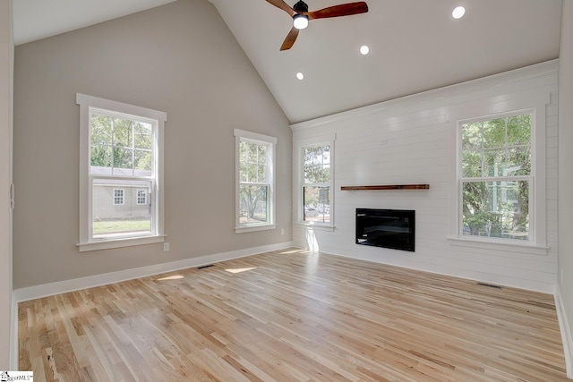 unfurnished living room featuring ceiling fan, high vaulted ceiling, and light wood-type flooring