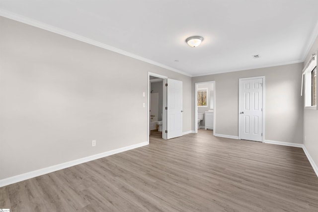 unfurnished bedroom featuring light wood-type flooring, ornamental molding, and multiple windows