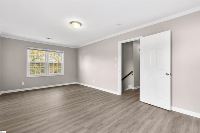 empty room with hardwood / wood-style floors and ornamental molding