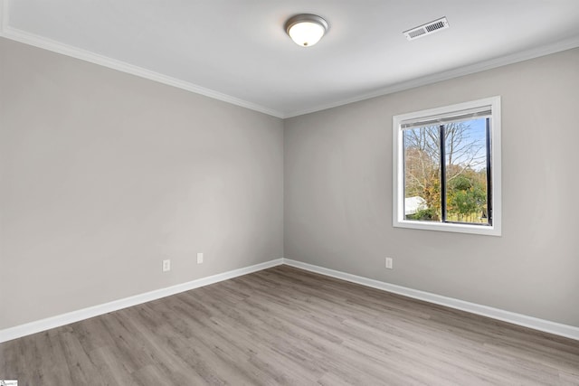 spare room with crown molding and light hardwood / wood-style flooring