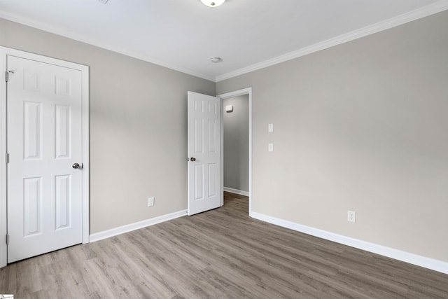 unfurnished bedroom with crown molding and light wood-type flooring