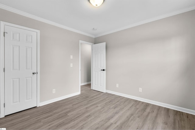 unfurnished bedroom with crown molding and light wood-type flooring