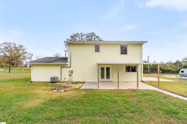 back of property with a lawn, central AC unit, and a patio