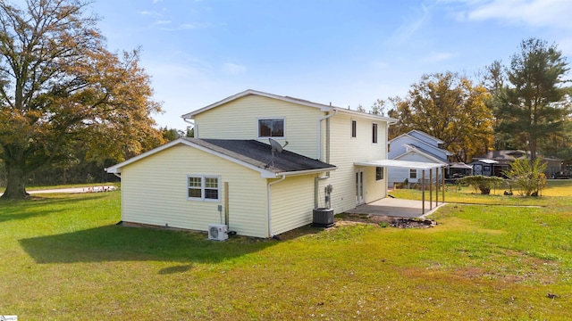 rear view of house featuring a patio, central air condition unit, and a lawn