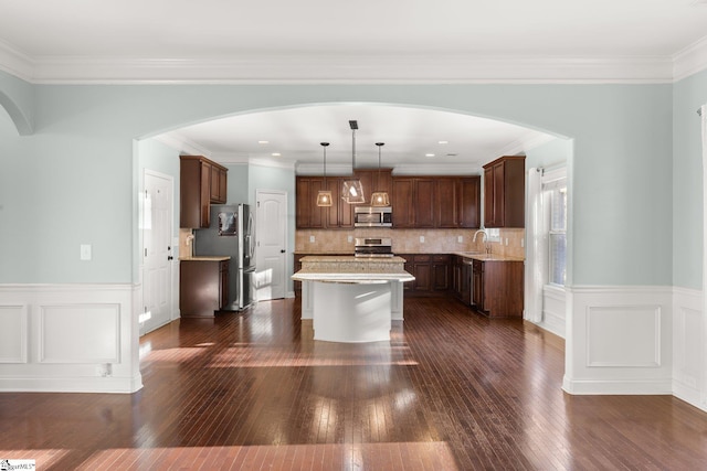 kitchen featuring pendant lighting, decorative backsplash, a kitchen island, and dark hardwood / wood-style floors