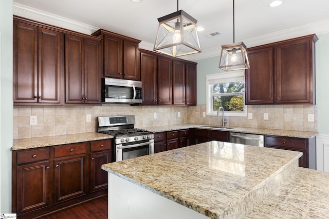 kitchen with sink, ornamental molding, stainless steel appliances, and hanging light fixtures