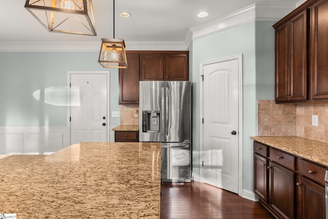 kitchen featuring light stone countertops, stainless steel fridge, backsplash, dark wood-type flooring, and decorative light fixtures