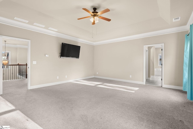 carpeted empty room featuring ceiling fan, crown molding, and a tray ceiling