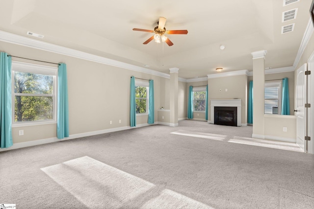 unfurnished living room featuring light carpet, a tray ceiling, ceiling fan, and crown molding