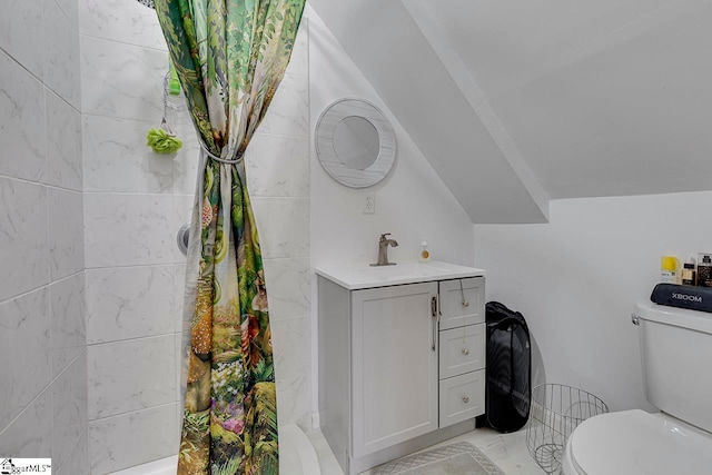 bathroom with vanity, toilet, lofted ceiling, and walk in shower