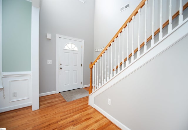 foyer entrance with a high ceiling and light hardwood / wood-style flooring