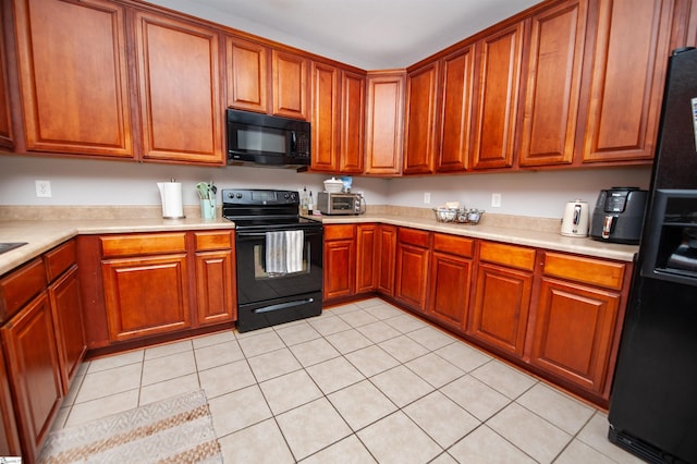 kitchen featuring light tile patterned floors and black appliances