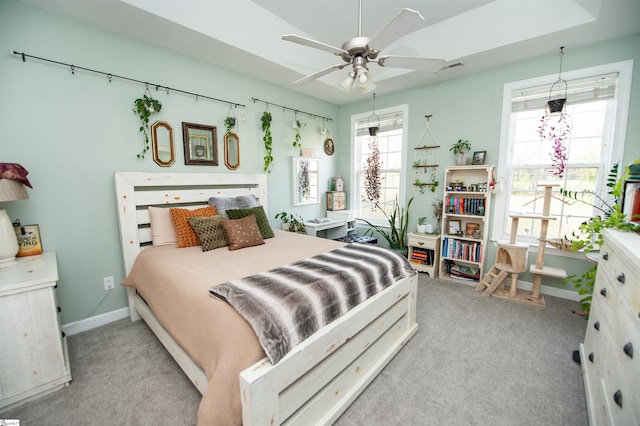 carpeted bedroom featuring ceiling fan and multiple windows