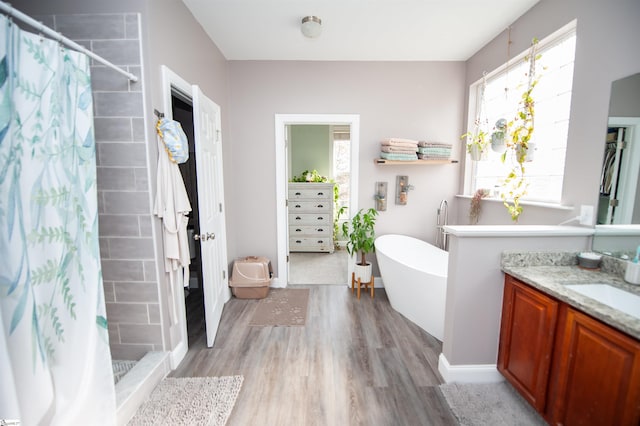 bathroom with wood-type flooring, vanity, and shower with separate bathtub