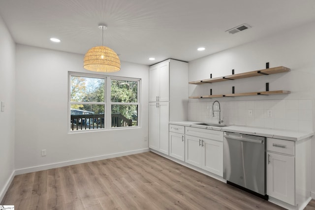 kitchen featuring white cabinets, sink, light hardwood / wood-style flooring, dishwasher, and hanging light fixtures