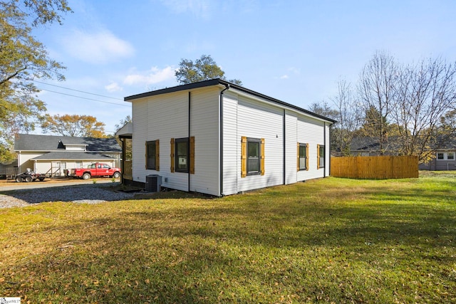 view of side of home with a lawn and central air condition unit