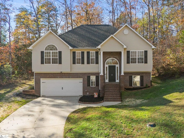 raised ranch with a garage and a front lawn