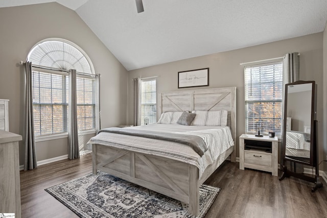 bedroom with dark hardwood / wood-style floors, vaulted ceiling, multiple windows, and ceiling fan