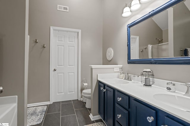 bathroom with tile patterned flooring, vanity, a shower with shower door, and toilet