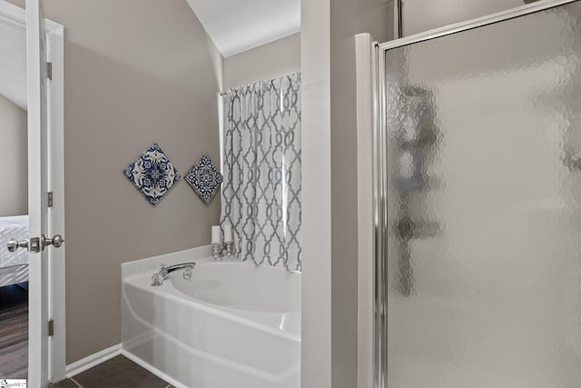 bathroom featuring hardwood / wood-style floors, plus walk in shower, and a textured ceiling