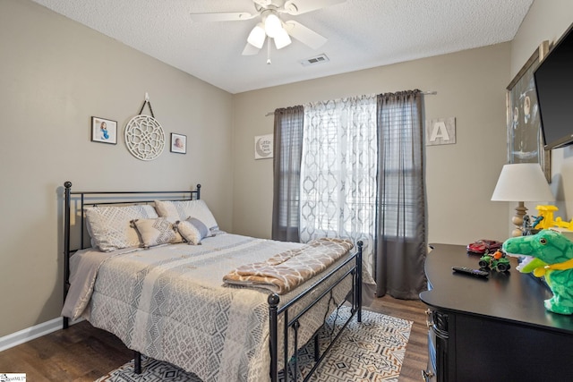 bedroom featuring ceiling fan, wood-type flooring, and a textured ceiling