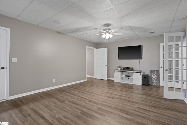 unfurnished living room featuring a drop ceiling and hardwood / wood-style flooring